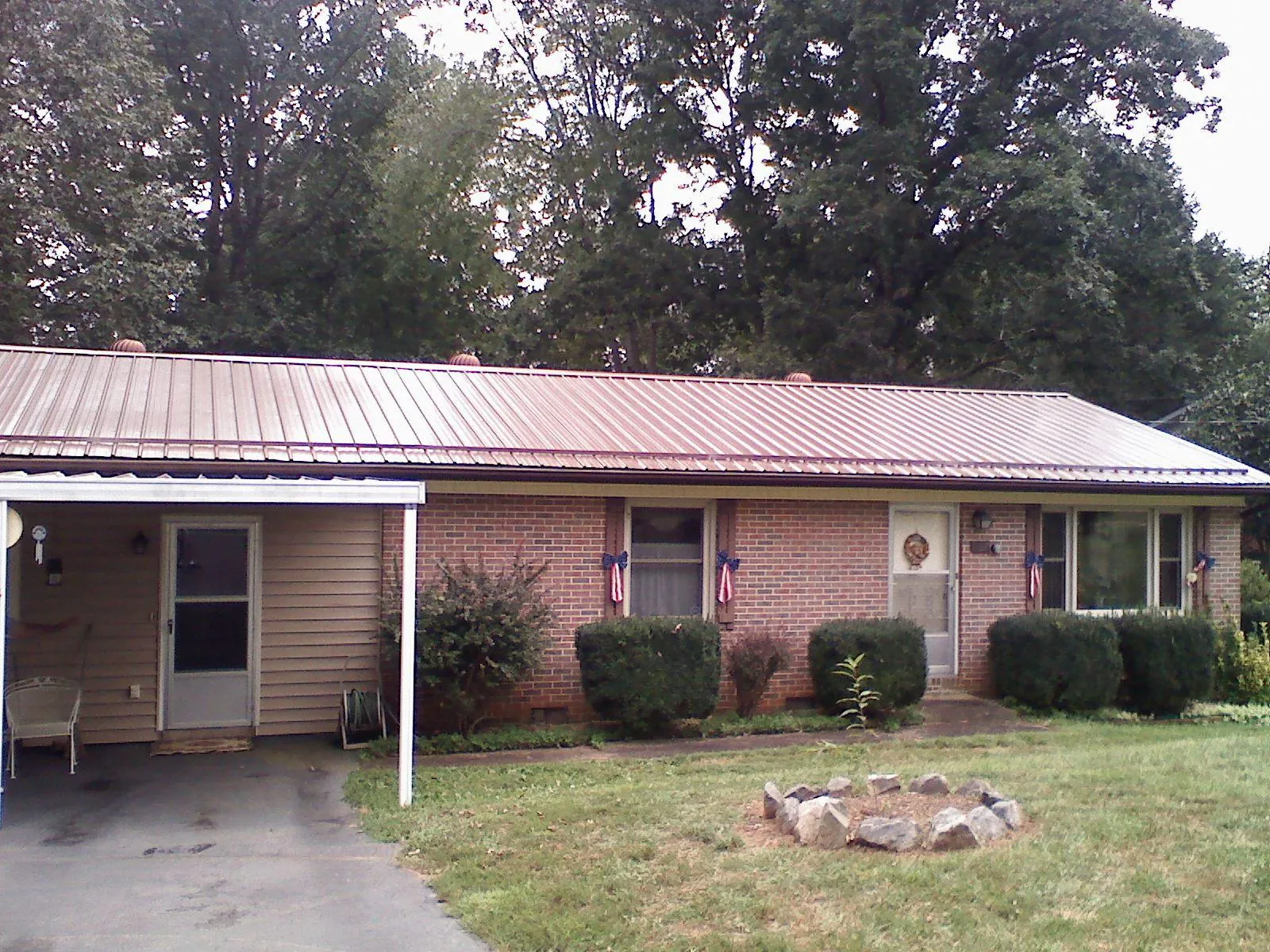 Bronze metal roof and carport on a brick ranch home — Roof Repair work by our crew in Biglerville